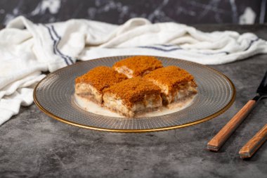 Bisküvili soğuk baklava. Koyu arkaplanda bisküvi dolu soğuk baklava. Yerel adı lotuslu soguk baklava