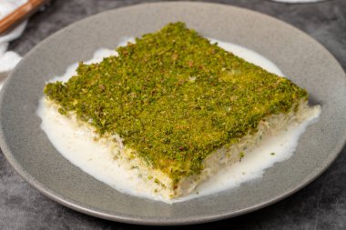 Şam fıstıklı soğuk kadayif. Siyah arka planda fıstıklı sütlü kadayf tatlısı. Yerel adı Soguk Kadayif Tatlisi. Üst görünüm