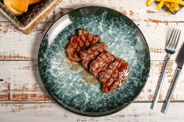 Freshly grilled beef tenderloin slices. Slices of cooked tenderloin on wood background. high quality photo. Top view