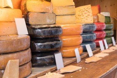 Dükkan tezgahında çeşitli ve farklı peynir çeşitleri var. Dükkanda bir sürü peynir ve boş etiket.