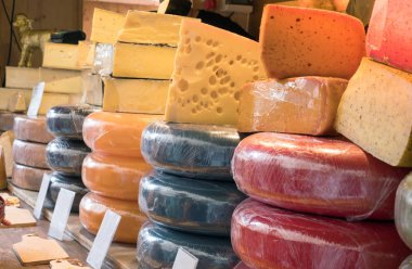 Dükkan tezgahında çeşitli ve farklı peynir çeşitleri var. Dükkanda bir sürü peynir ve boş etiket.