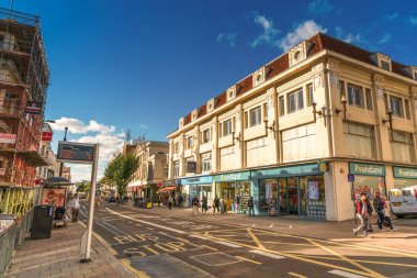 Brighton, İngiltere-1 Ekim 2018: Brighton şehir merkezinde trafik yoğunlaşan iki çift katlı kırmızı otobüsü olan yolcular için dijital veri tabelalı otobüs durağı..