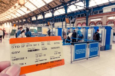 Brighton, İngiltere-18 Ekim 2018: Brighton & Hove tren istasyonunda arka plandaki self servis bilet makinesinden tren bileti alan bir grup yolcuyla el ele tutuşan Uk Demiryolu Dönüş Bileti
