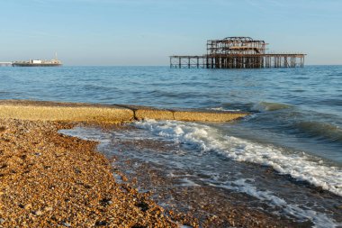 Brighton Rıhtımı 'nın eski kalıntıları Brighton ve Hove' un Batı İskelesi 'nde güzel dalgalarla denizde kaldı. Eski moda West Pier Brighton Sahili.