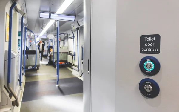 Automatic door occupied lavatory toiled open and close button on train in UK. Train toilet door lock and unlock system control.