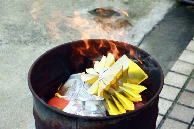 Çinlilerin ölü ataları için gümüş ve altın sahte para kağıtlarını yakmak. Yeni yılda Çin 'de metal kovaları yakan kağıt para öldü..
