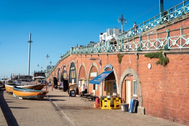 Brighton, İngiltere-18 Ekim 2018: Brighton Rıhtımı ve Brighton İskelesi merdiveni, ziyaretçi, tekne ve İngiliz Havayolları i360 gökyüzü kulesi ile birlikte deniz kenarındaki bar birası.