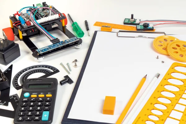 Robot line tracking designing and assembling in above view with engineering tools, sensor and blank paper for note idea. Robot and microcontroller tools for make innovation.