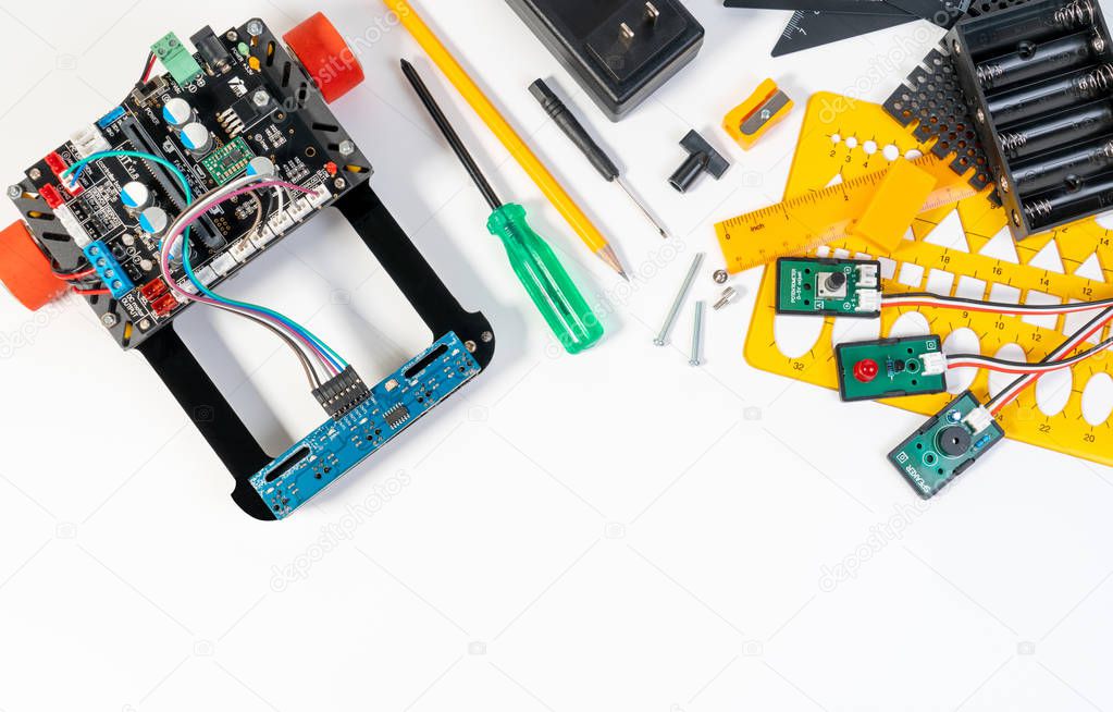 Robotics line tracking sensors development closeup and electronic invention engineer, programmer, inventor with cables, wires, robot micro controller board and constructing robot tools for technologies background.