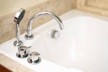Asya Oteli klasik lüks banyo, banyo küveti ve beyaz seramik musluk eski moda. Beyaz odada modern krom banyo musluğu.