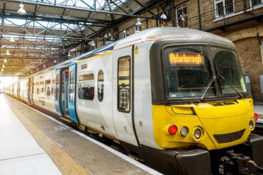Londra tren istasyonunda yerli halk ve grup turistleri Londra Kings Cross İstasyonu 'nda yürüyor ve tren bekliyor. Harry Potter filmlerinin en ünlü istasyonu..