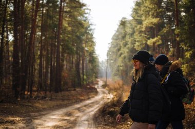 Mutlu arkadaşlar güneşli ormanda yürüyorlar