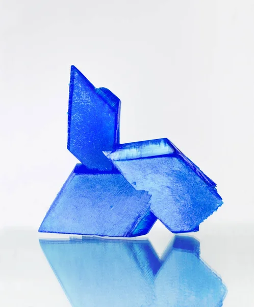 Modré Krystaly Síranu Měďnatého Zrcadlovém Povrchu Bílé Pozadí Modrý Vitriol — Stock fotografie