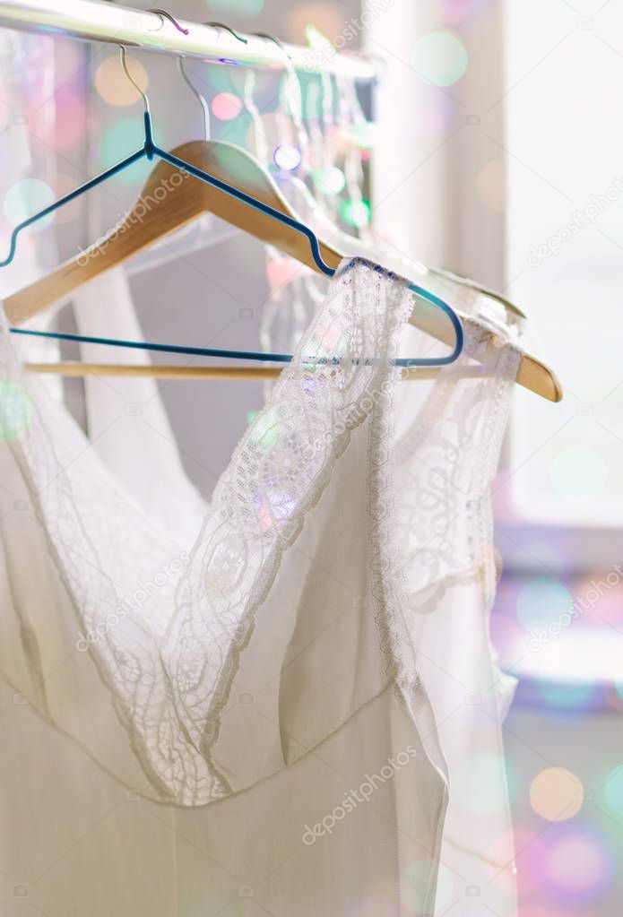 Vintage lace bridal wedding white lingerie on hangers, mid century style, selective shallow focus