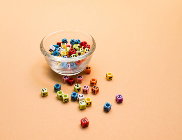 Цветные кубические буквы Стеклянная чашка на оранжевом фоне
.