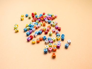 Turuncu arka plan üzerinde renkli küp harfler.