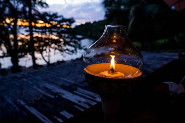 Kaars lamp op tafel met zee en zonsondergang. — Stockfoto