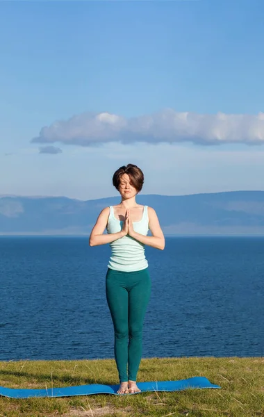 Женская йога. Женщина практикует медитацию на побережье — стоковое фото