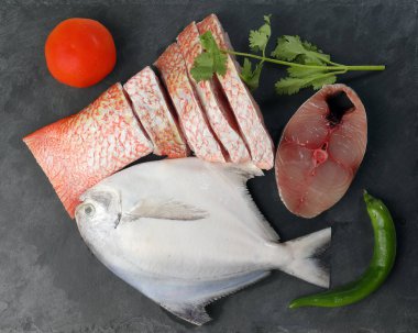 Degutted dilimlenmiş fileto parçaları siyah mermer arduvaz arka plan üzerinde beyaz pomfret İspanyolca Uskumru red snapper balık temizlenmiş temizlenir