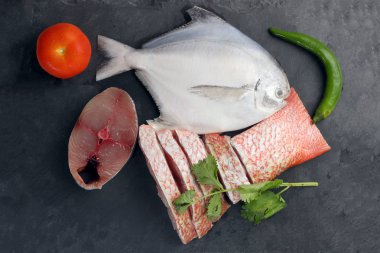 Degutted dilimlenmiş fileto parçaları siyah mermer arduvaz arka plan üzerinde beyaz pomfret İspanyolca Uskumru red snapper balık temizlenmiş temizlenir
