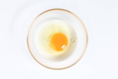 Beyaz arka plan çiğ yumurta sarısı ve beyaz sıvı saydam cam kase 