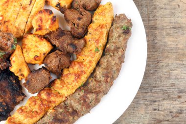 Karışık kömür ızgara tavuk eti koyun eti köfte eti şiş kebap tawook orta doğu Arap ahşap masa 