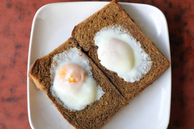Kahverengi kepekli brad tost üzerine haşlanmış kızarmış yumurta 
