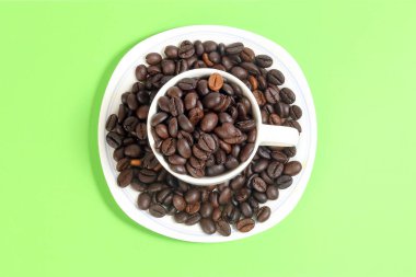 Yeşil renk arka plan kahve fasulye beyaz seramik fincan tabak 