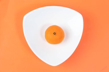 Mandalina Portakal Meyve dilim hart şekil plaka turuncu arka plan üzerinde ayıklanmış yarım meyve suyu 