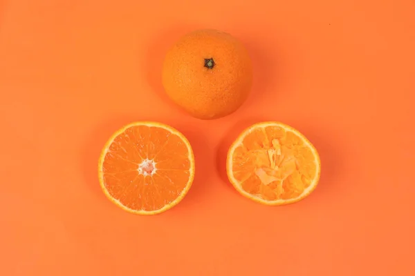Mandarin Orange Fruit slice half juiced extracted on orange background