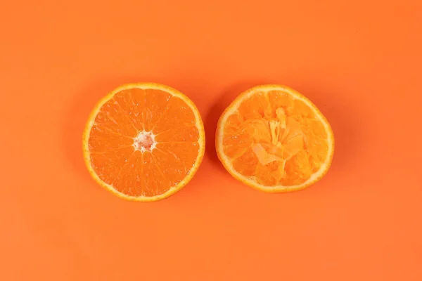 Mandarin Orange Fruit slice half juiced extracted on orange background