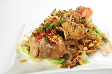 Bol yağda kızartılmış tatlı su. Tayland usulü limonotlu kişniş soğan soslu bütün tilapia balığı dilimlenmiş fileto.