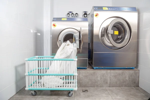 Washing machine overloaded with clothes and empty basket in laundry — Stock Photo, Image