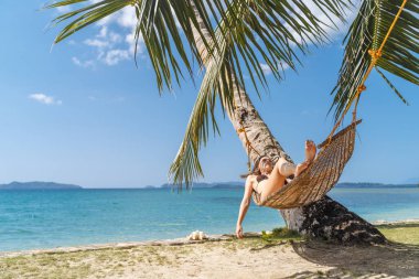 Yaz tatil kavramı, mayo kadında rahatlatıcı bir hamak bir tropik sahilde El Nido Palawan Adası, Filipinler