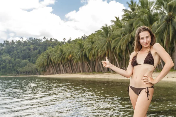 夏のフィリピンの休暇旅行 ヤシの木の背景とエキゾチックな熱帯のビーチでジェスチャーを承認する親指をやって幸せな女 パラワン フィリピン — ストック写真