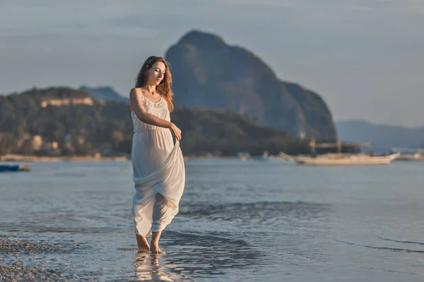 Mulher de vestido branco no mar ao pôr do sol na ilha de Palawan, Filipinas — Fotografia de Stock