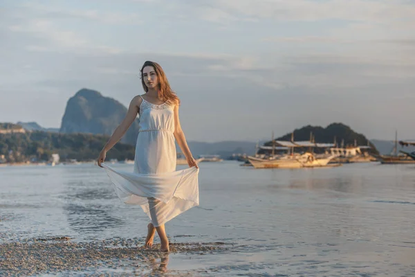 Mulher de vestido branco no mar ao pôr do sol na ilha de Palawan, Filipinas — Fotografia de Stock