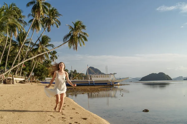 Menina de vestido branco correndo ao longo da praia El Nido nas Filipinas . — Fotografia de Stock