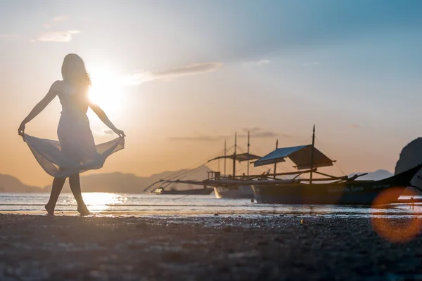 Siluet kadın ve geleneksel Filipino tekneler Palawan Adası Filipinler sunset plajında. El Nido gün batımı. Sunset Bulvarında dans. Erkek günbatımı, siluet.