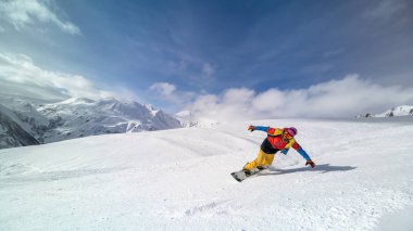 Etkin adam snowboard yamaçta güzel güneşli gün boyunca ountains içinde sürme..