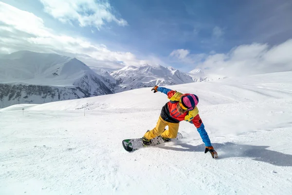 Uomo attivo snowboarder equitazione sul pendio durante la bella giornata di sole nei rimbalzi . — Foto Stock