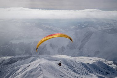 Güneşli kış aylarında kayak beldesi üzerinde karlı dağlarda Paragliding d