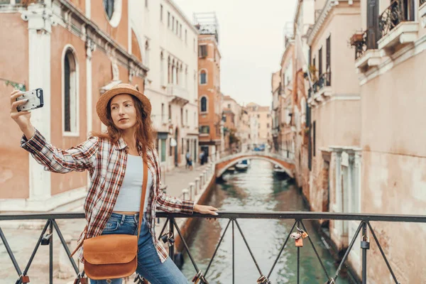 Frau macht Selfie-Foto mit Smartphone in Venedig. Reisefrau beim Selbstporträt auf venezianischer Brücke mit schöner Landschaft im Hintergrund, Venedig, Italien. — Stockfoto