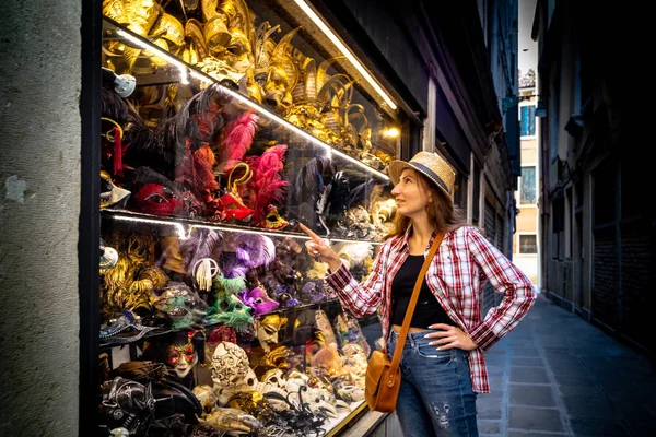 Junge Frau, die im Geschäft eine venezianische Maske erwählt — Stockfoto