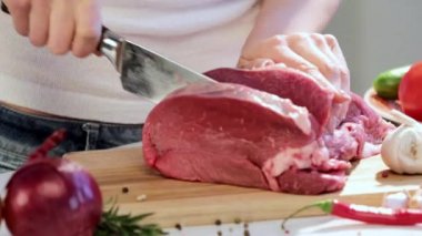 Mutfakta yemek pişiren kadınların ellerini kapatın. Ev hanımı taze et kesiyor..