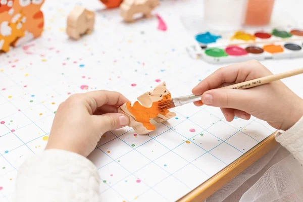 子供の手で水彩ブラシで木のおもちゃをペイント — ストック写真