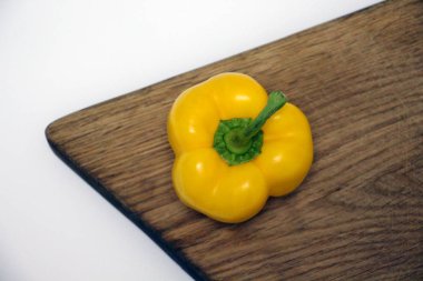 Ahşap kesme tahtası üzerinde sarı dolmalık biber