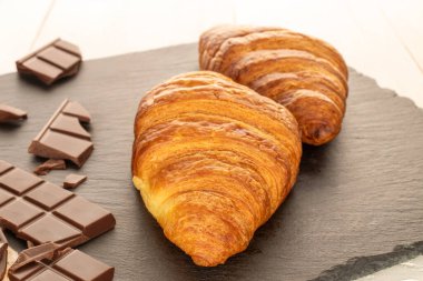 Çikolatalı kruvasanlar kayrak taşı üzerinde, yakın plan..