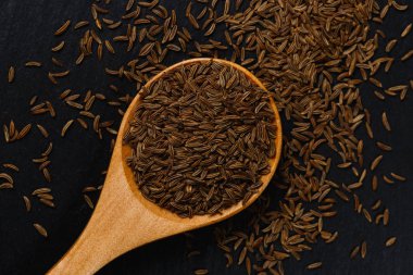 Tahta kaşık karabiber baharat. Kara biber baharat siyah taş düz yatıyordu. Kara biber baharat, üstten görünüm. Organik gıda, sağlıklı bir yaşam tarzı. Metin için yer