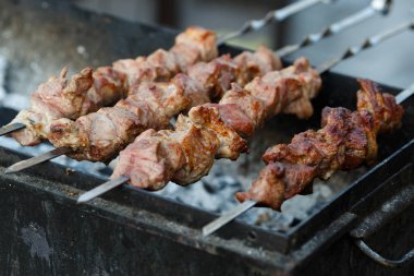 Metal şişte pişen ızgara kebap. Barbeküde pişmiş et. Barbekü taze et dilimleri. Geleneksel doğu yemeği, şiş kebap. Kömür ve alevler üzerine ızgara, piknik, sokak yemekleri